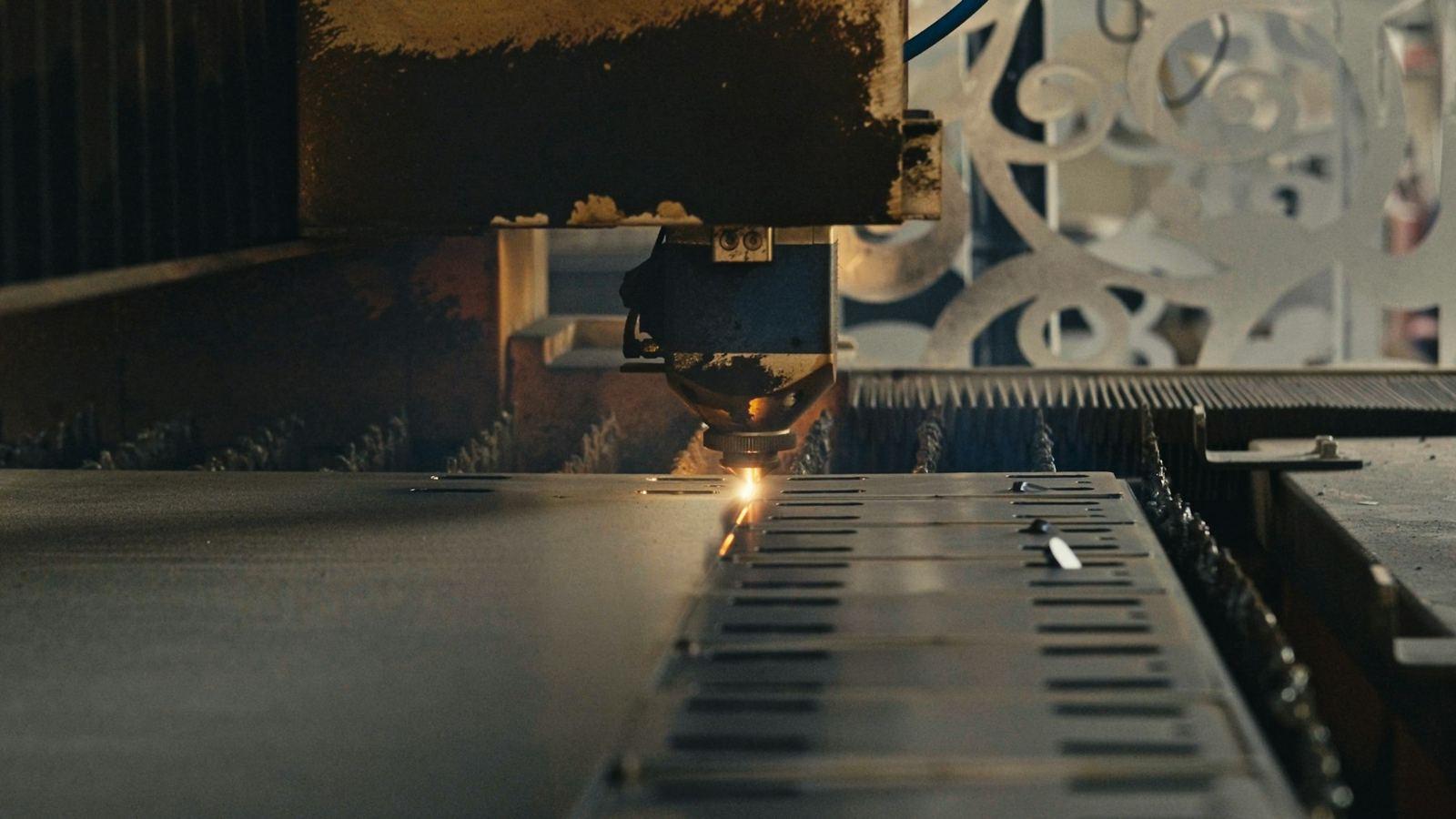 Representative photograph of a laser cutting head profiling a metal sheet